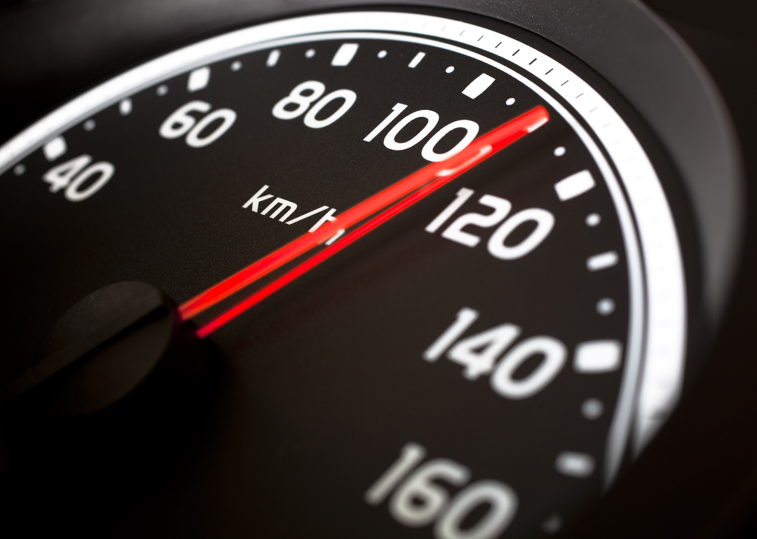 A car's speedometer showing a speed of 110 miles per hour.