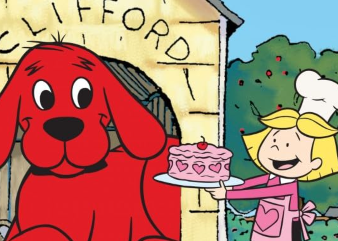 Emily holding out a birthday cake next to Clifford the Big Red Dog.