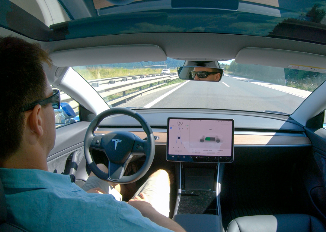 A person paying attention in a self-driving Tesla.