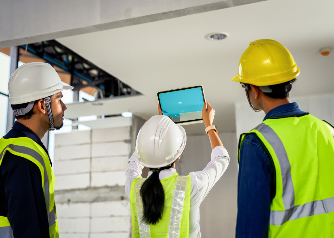 A construction engineering team using technology software through tablets to scan building construction