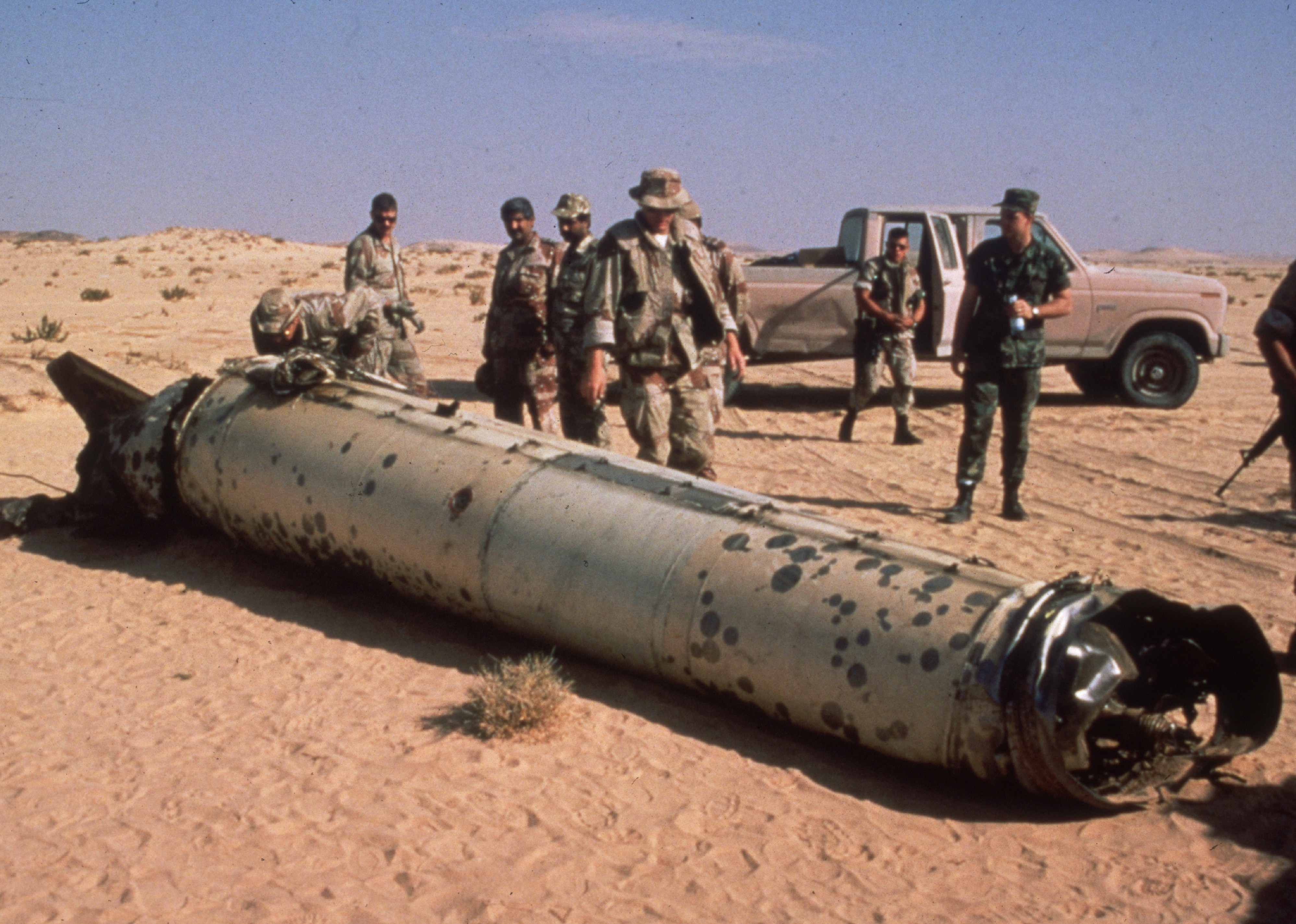 Allied troops stand around the remains of an Iraqi Scud missile in the desert during Operation Desert Storm.