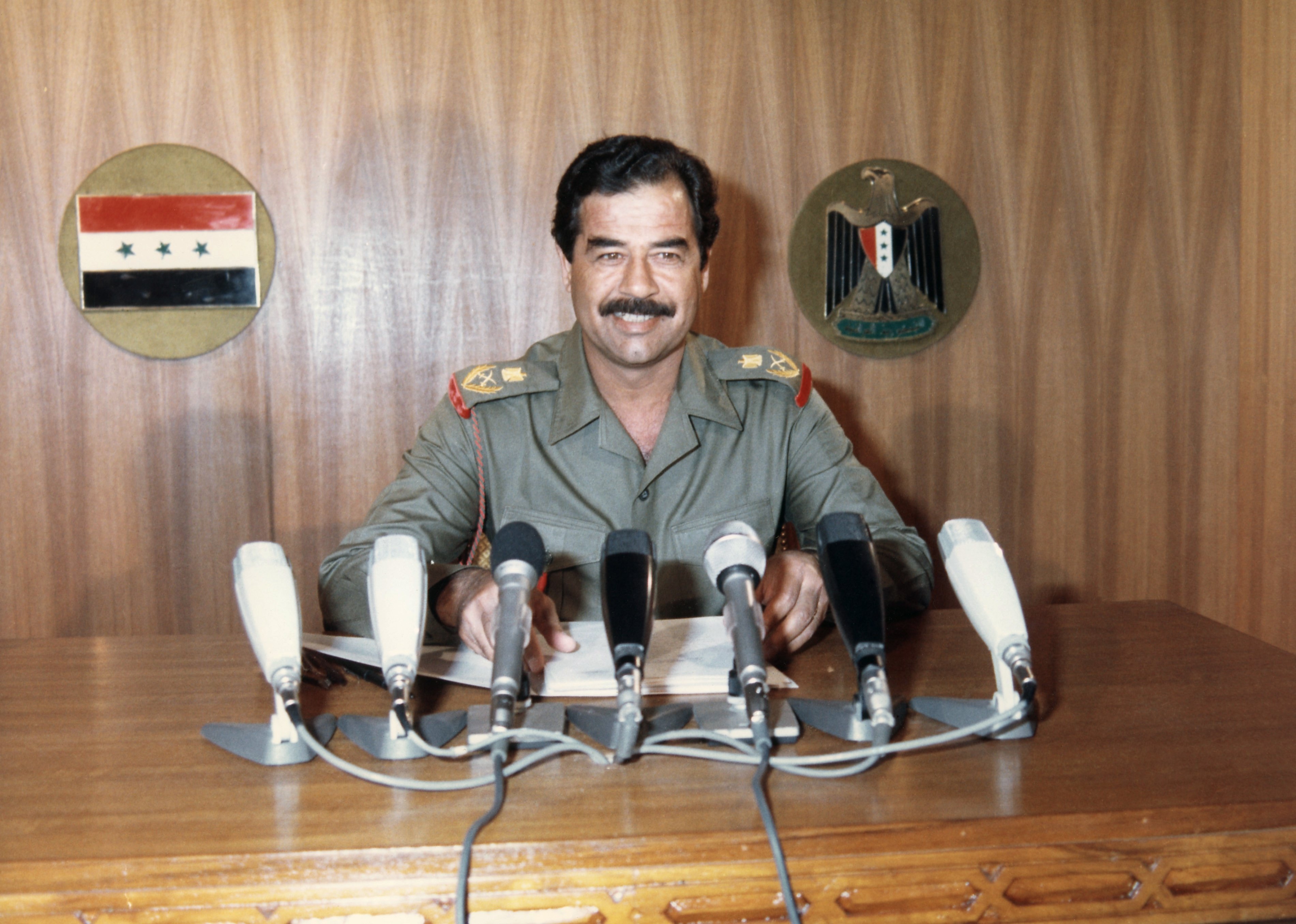 Saddam Hussein gives a report at a press conference,