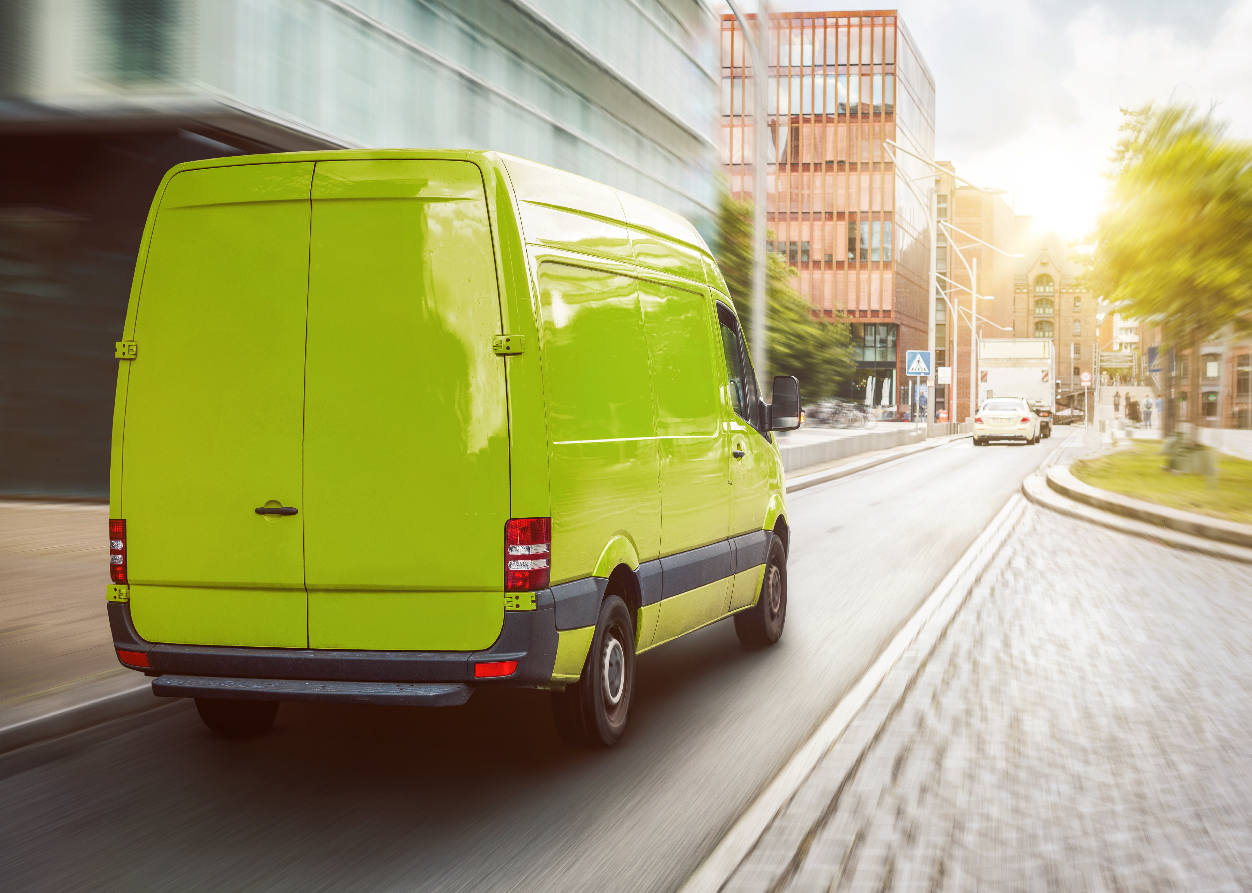 Green cargo van driving in the city