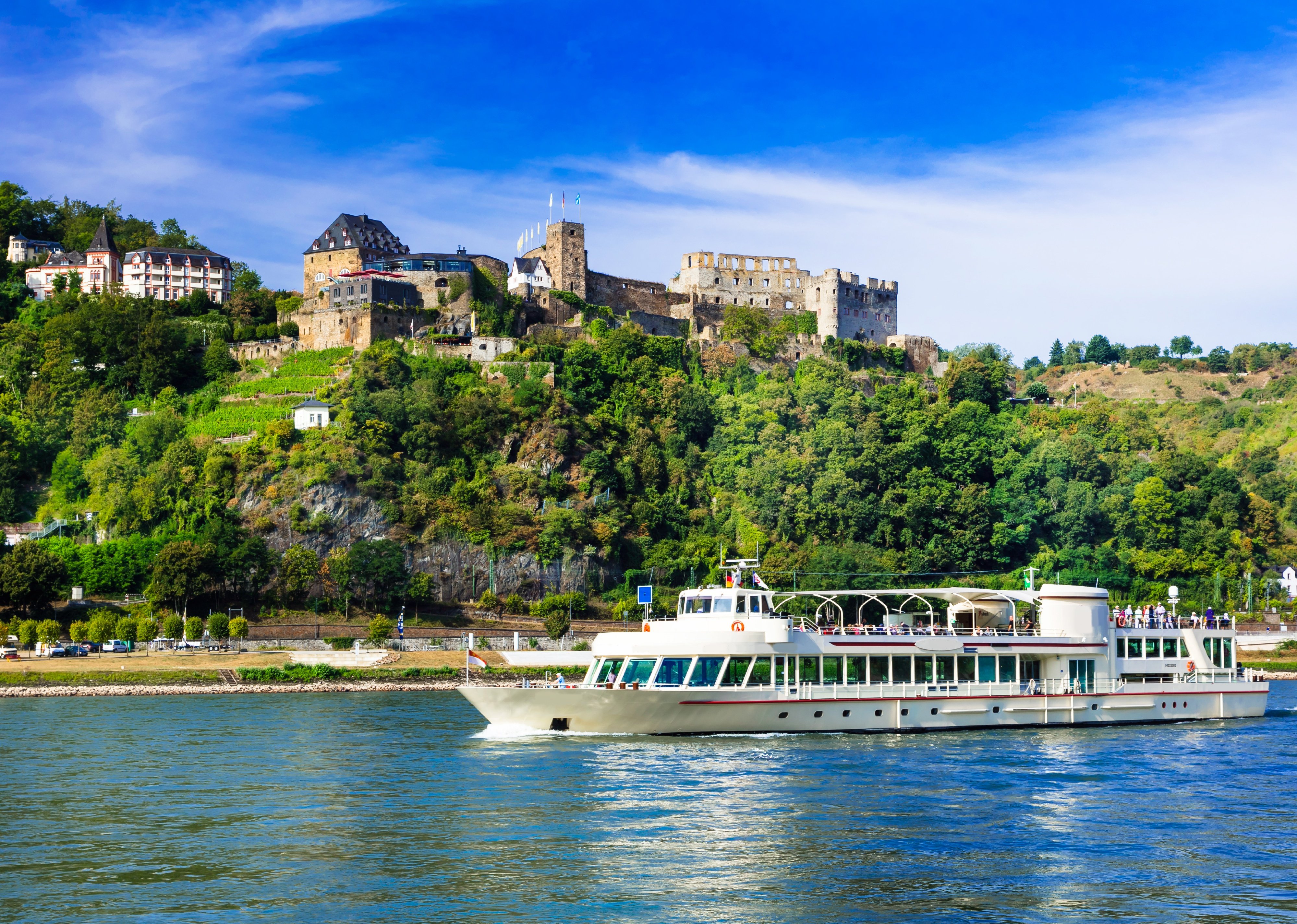 River cruise boat over Rhine with medieval castles in background.