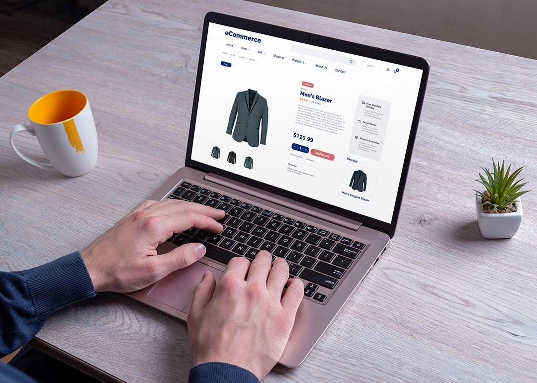 Person using a laptop to shop for men's blazer online.
