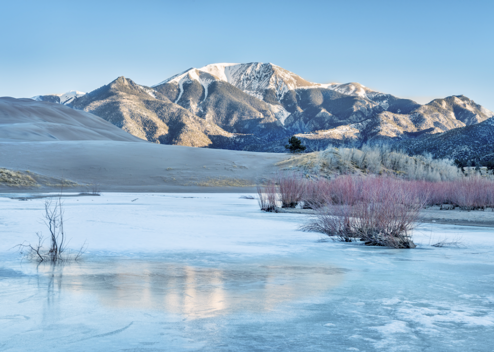 The Great Sand Dunes National Park with a frozen lake.
