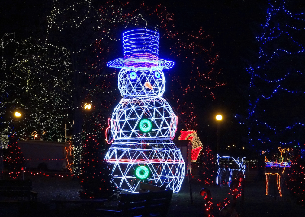 A lit up snowman decoration illuminated at night.