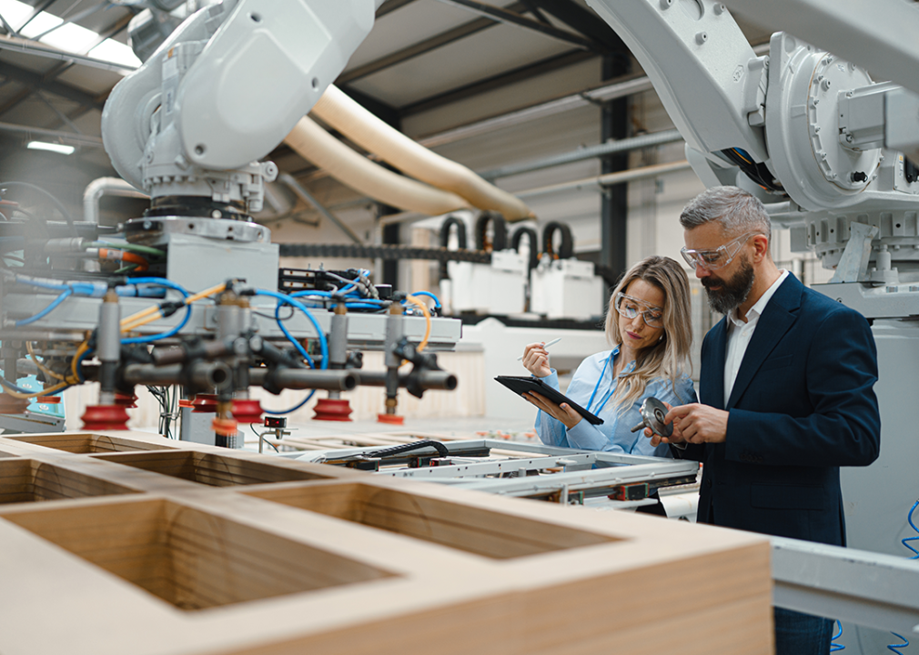 Engineer and project manager discuss production in modern industrial factory.