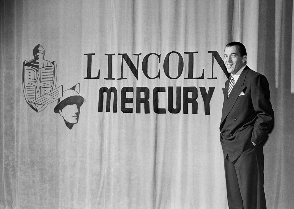 Ed Sullivan poses by the Lincoln Mercury sign on the curtain during the "Toast of the Town" show.