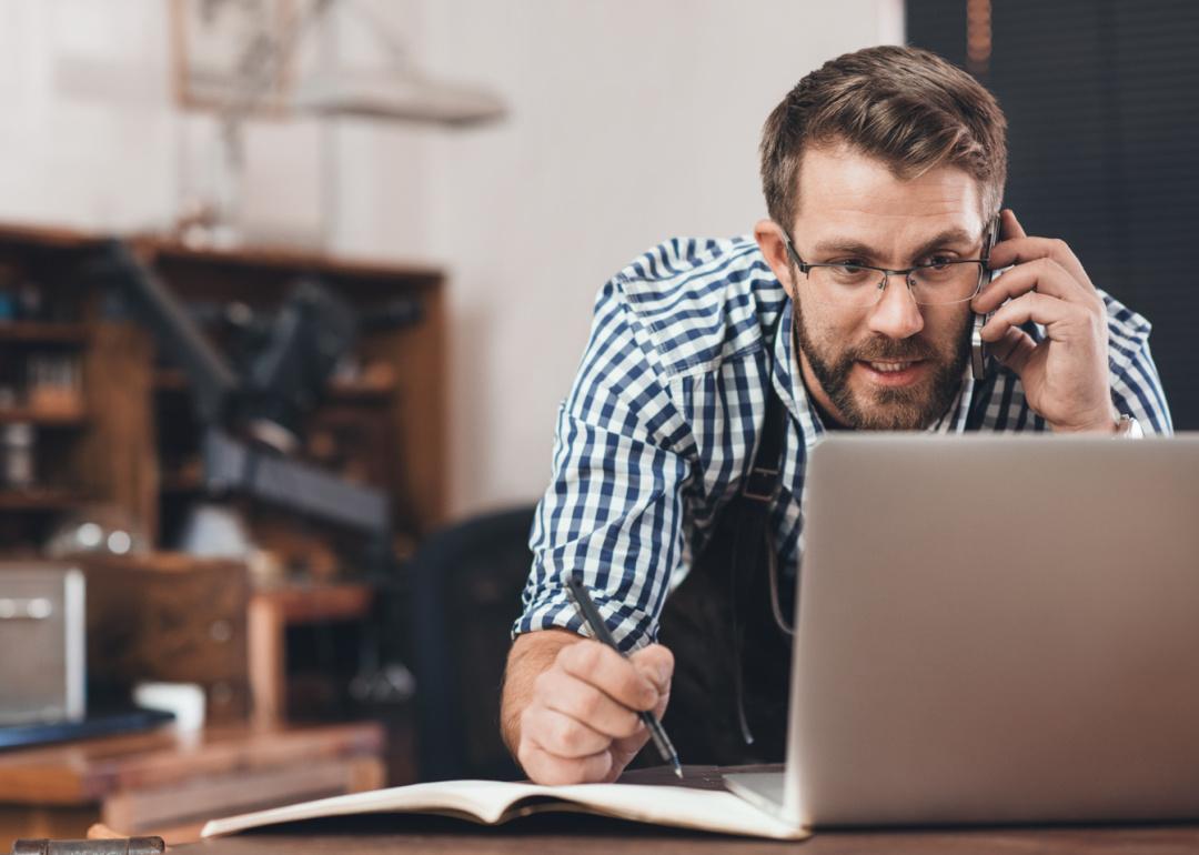 Small business owner on telephone with laptop.