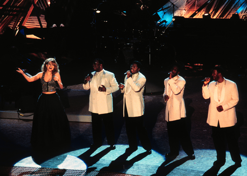 Mariah Carey performing with Boys II Men onstage.