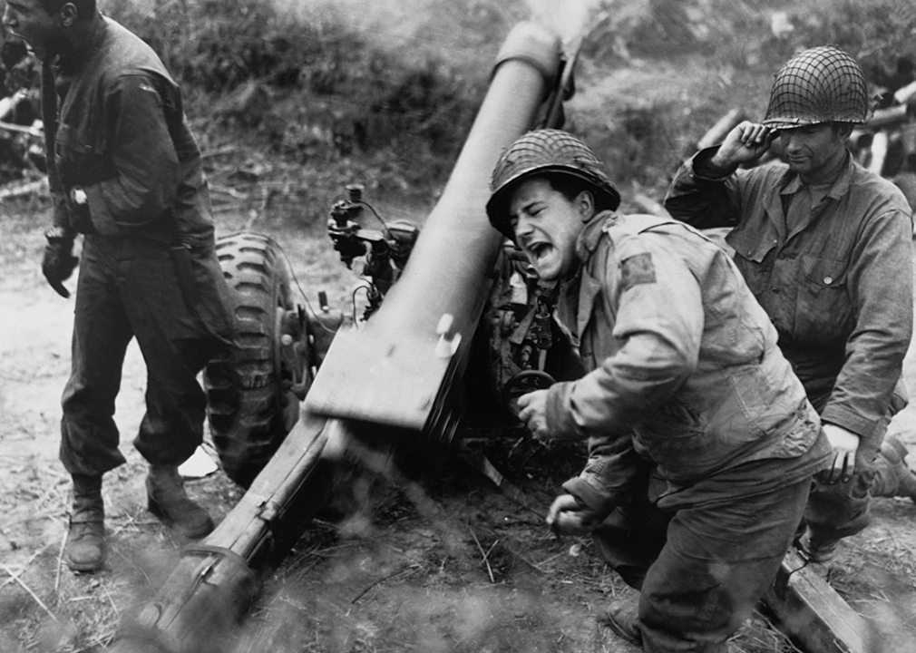 American soldiers fire howitzers at retreating German forces near Carentan, France.