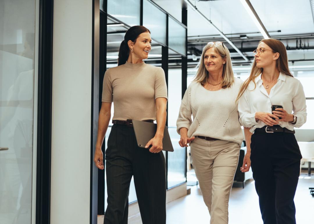 Three professional women touring an office space.