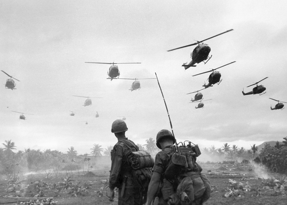 Combat helicopters fly over a radio telephone operator and his commander on an isolated landing zone during Operation Pershing.