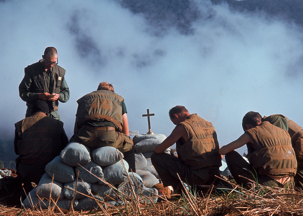 A chaplain leads a group of Marines in prayer.