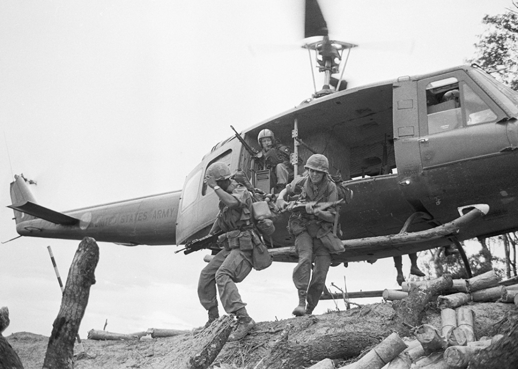 Four U.S. soldiers getting out of a helicopter.