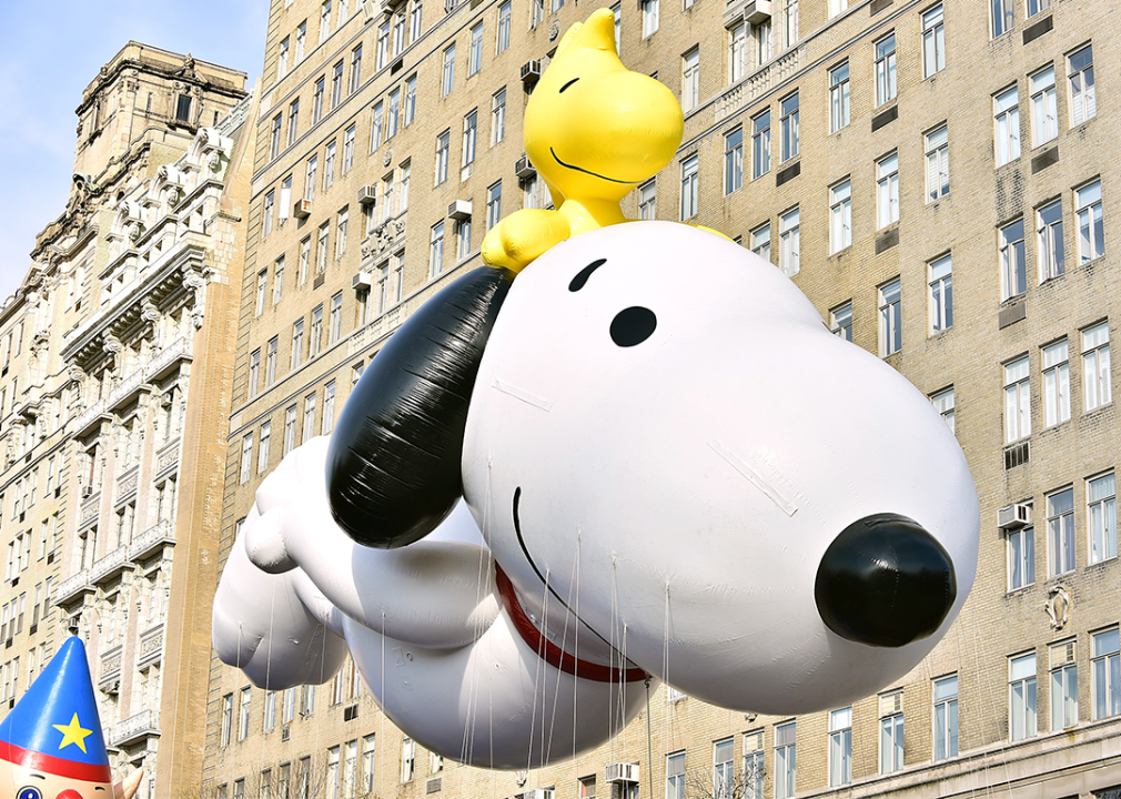 View of Snoopy and Woodstock balloon with a building in background.