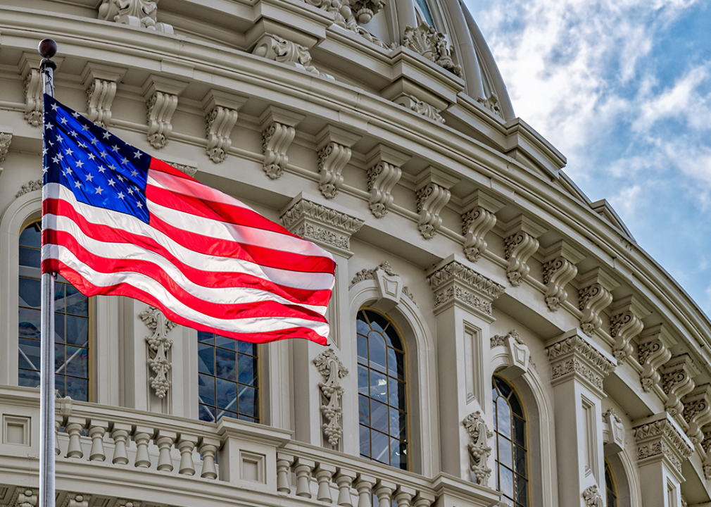 Capitol dome detail with waving American flag.