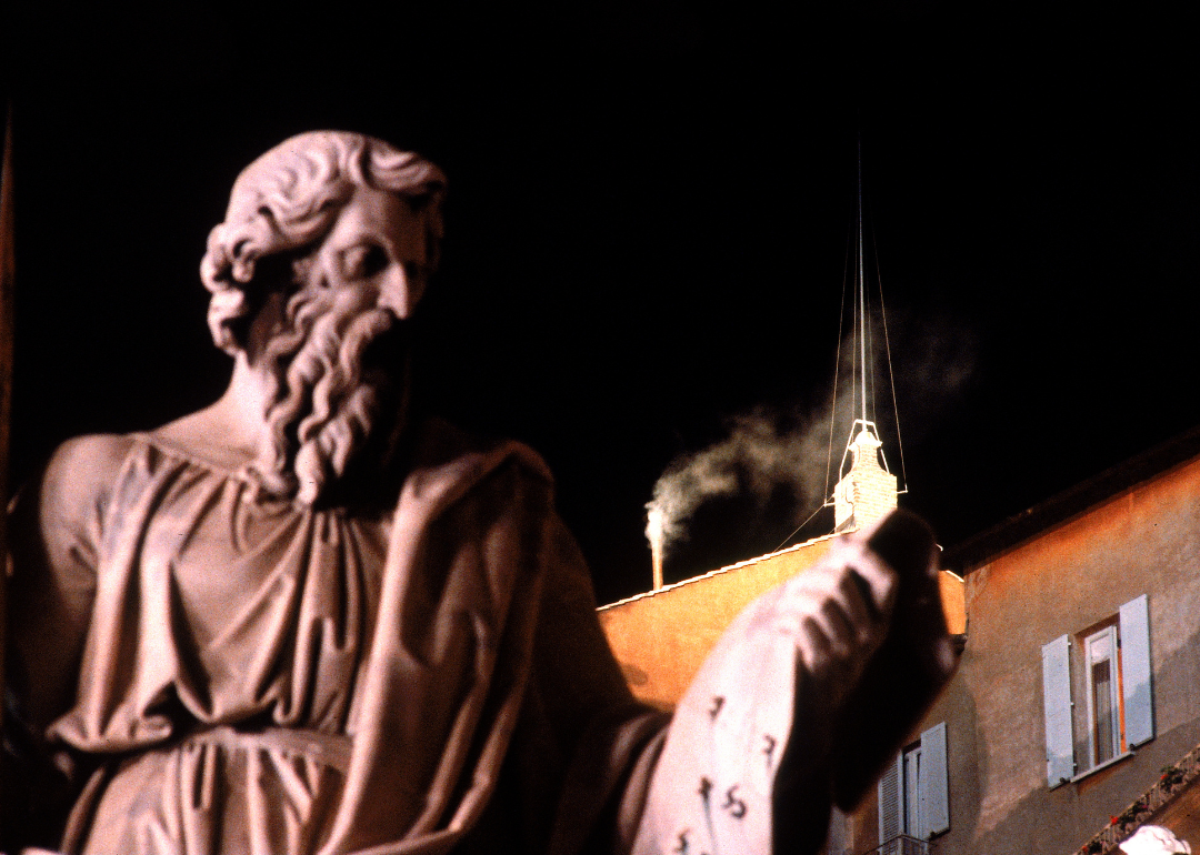 White smoke from the Sistine Chapel chimney at night.