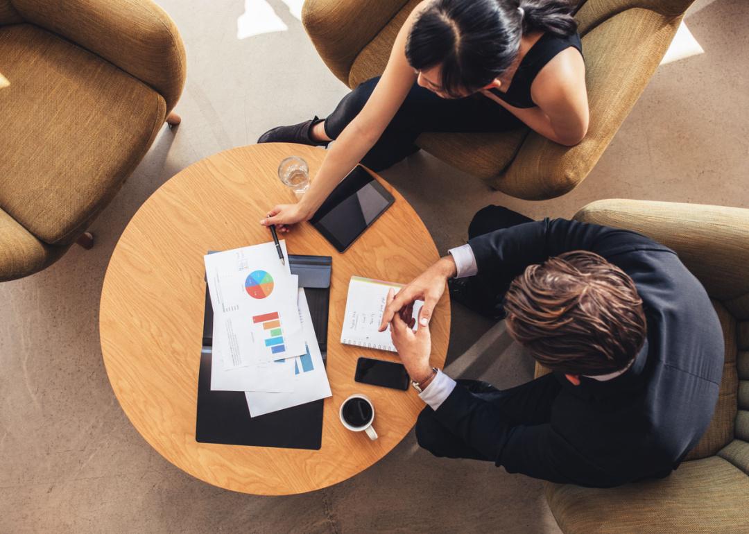 Top view of business colleagues sitting at table with charts.