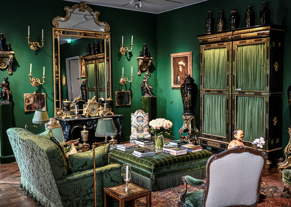 Green jewel tones interior with floral patterned furniture and ornate accents.