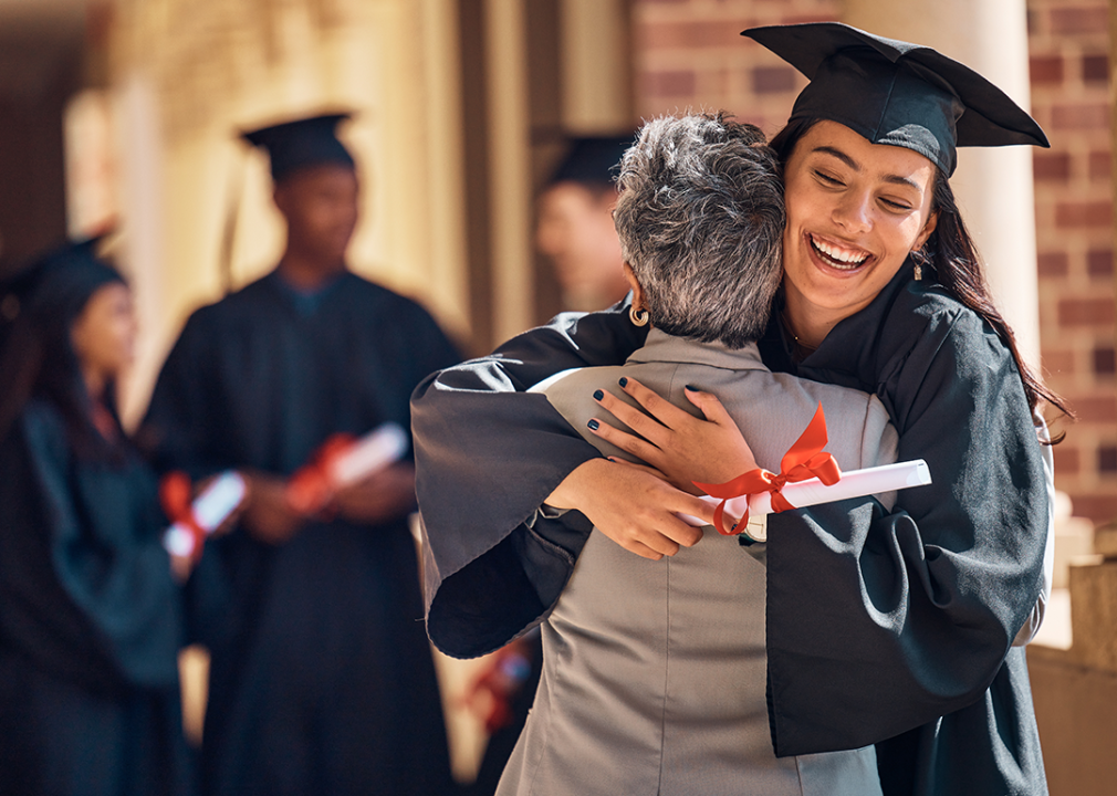 Graduate hugging parent at ceremony.
