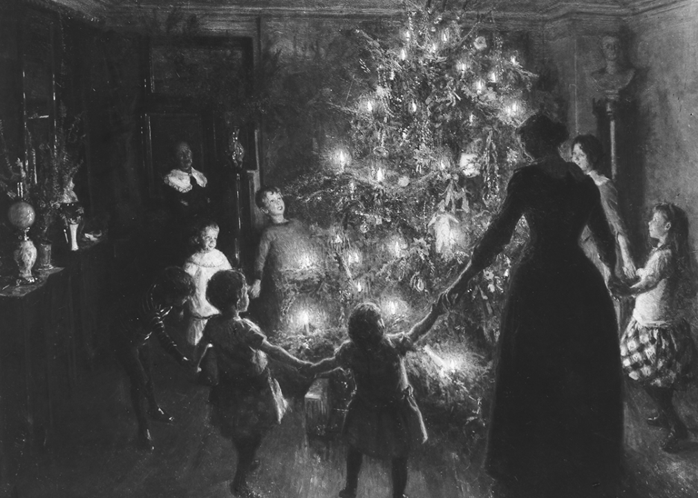 Illustration of family holding hands in a circle around a tree lit with candles.