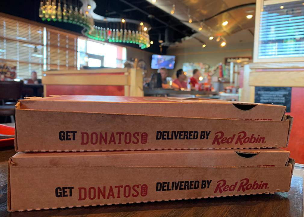 Stacked boxes of Donatos Pizza in restaurant.