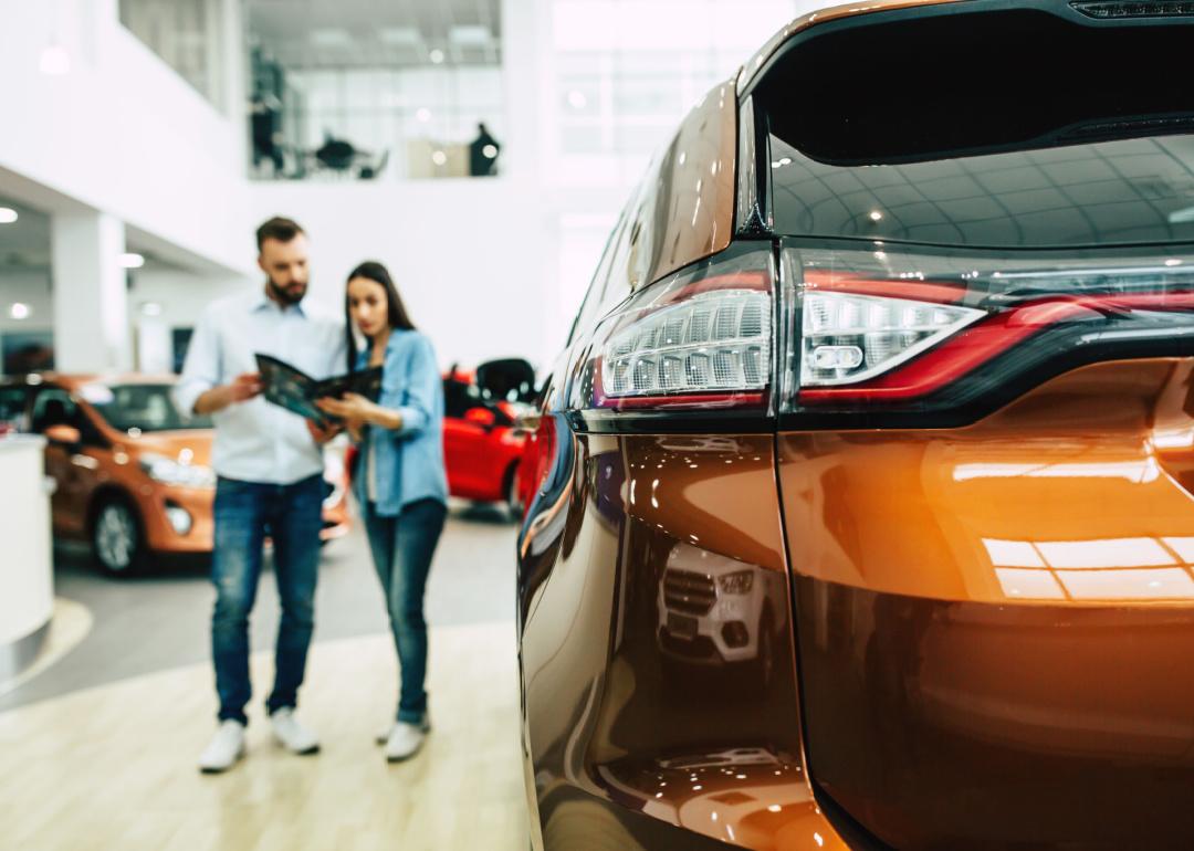 Couple choosing new car at dealership