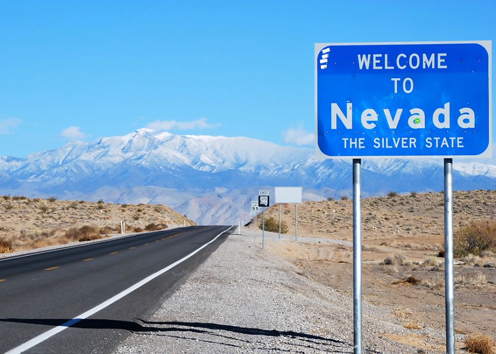 Welcome to Nevada road sign with mountains on the horizon.