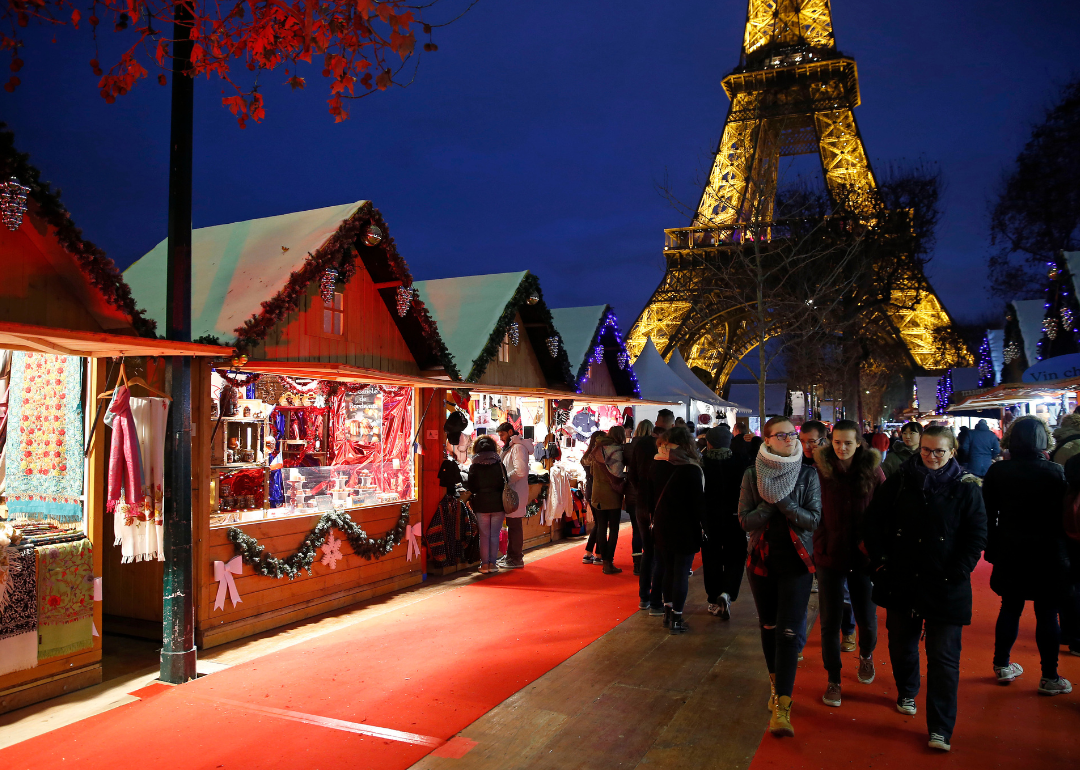 People visit the Christmas market next to the Eiffel Tower.