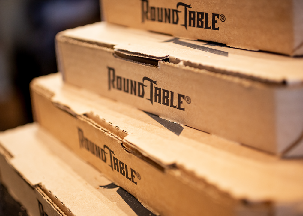 A closeup view of several stacked cardboard boxes by Round Table Pizza.