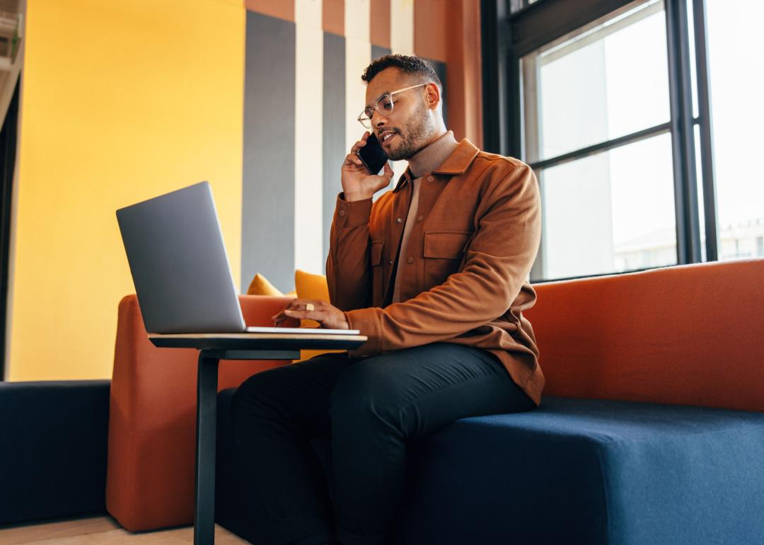 Businessman speaking on the phone and using a laptop.