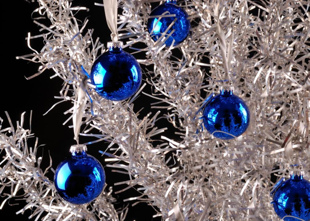 Close up aluminum christmas tree with blue ornaments.