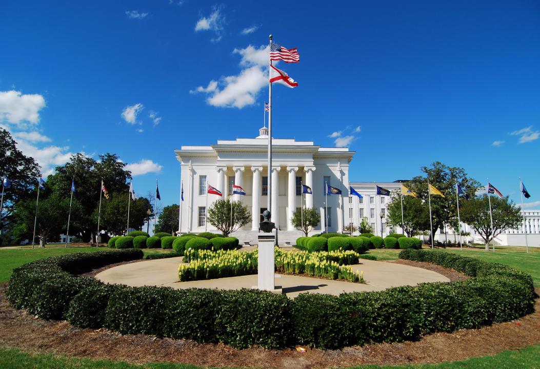 Alabama State Capitol with flags.