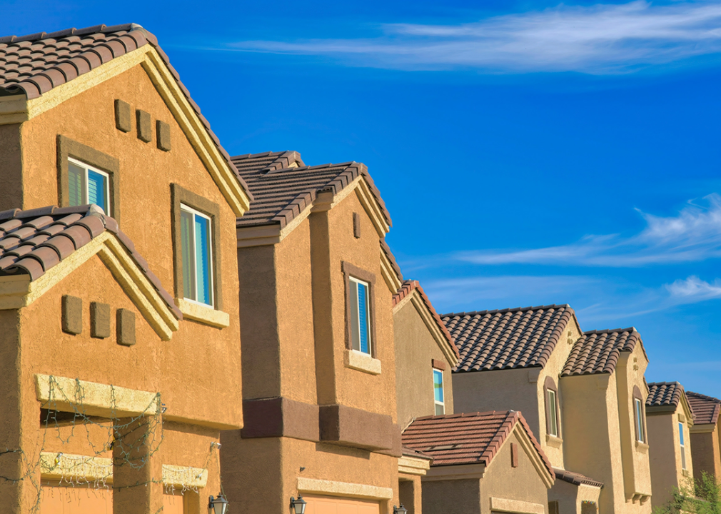 Row of houses with painted stucco walls against the blue sky.