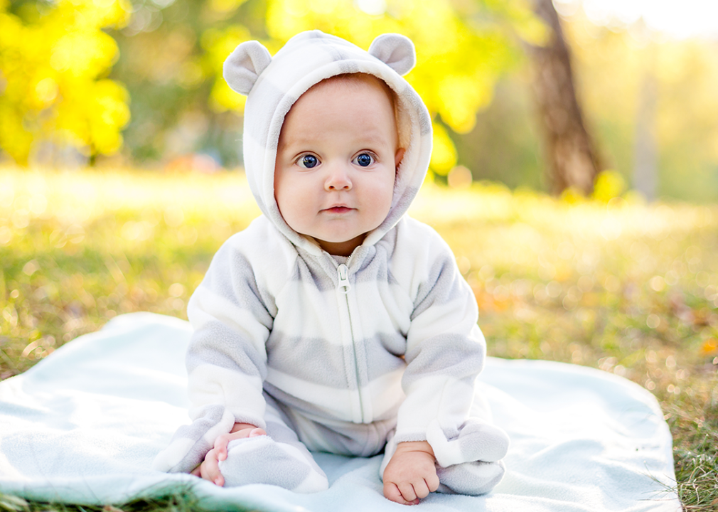 Boy in park sitting on blanket.