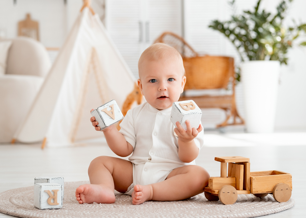 Baby playing with blocks in nursery.