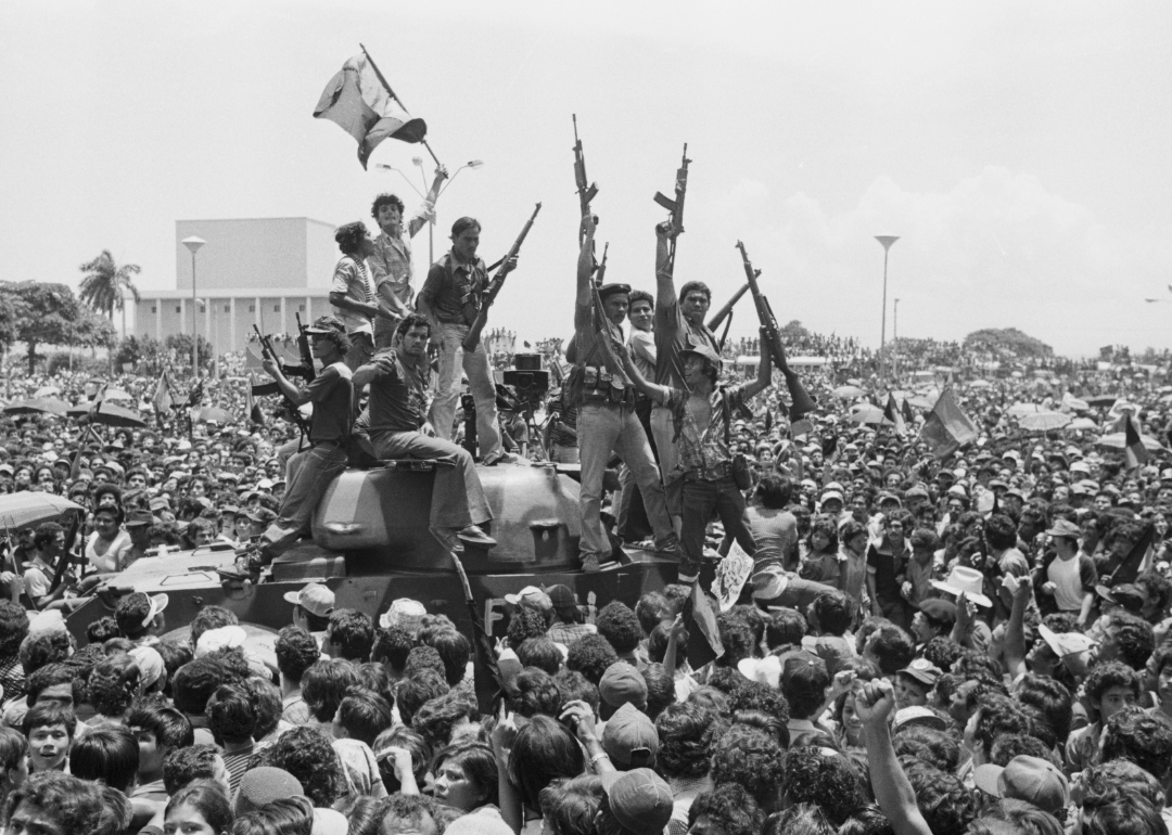 Sandinista rebels ride a tank in the main square of Managua.