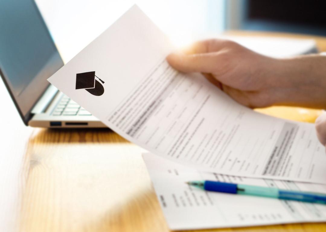 Person reading university application document.