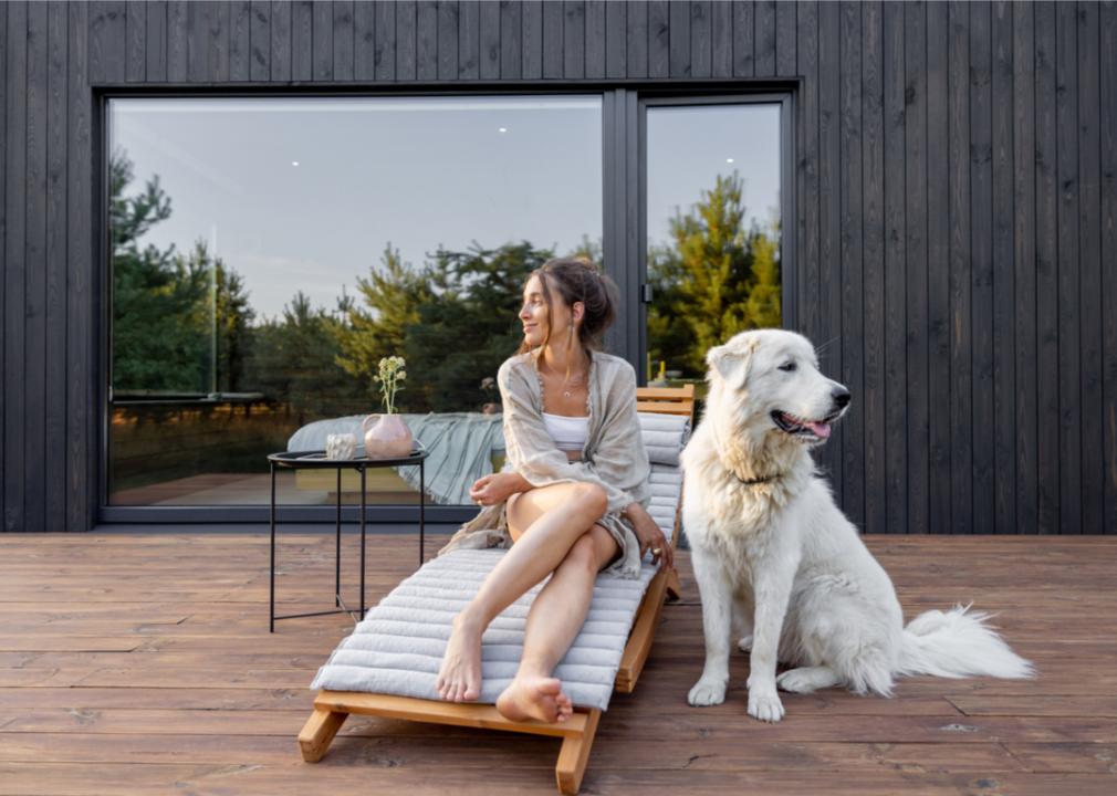 Woman and dog sit on modern terrace