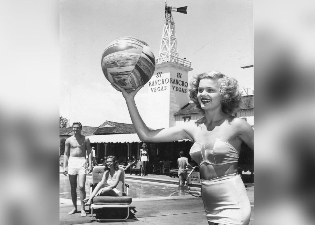 Woman poses with beach ball in front of El Rancho Vegas resort.