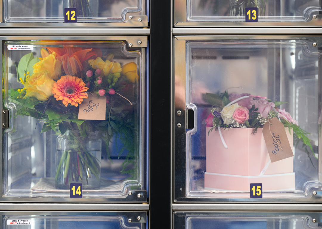 A bouquet of flowers and an arrangement of roses in a vending machine.