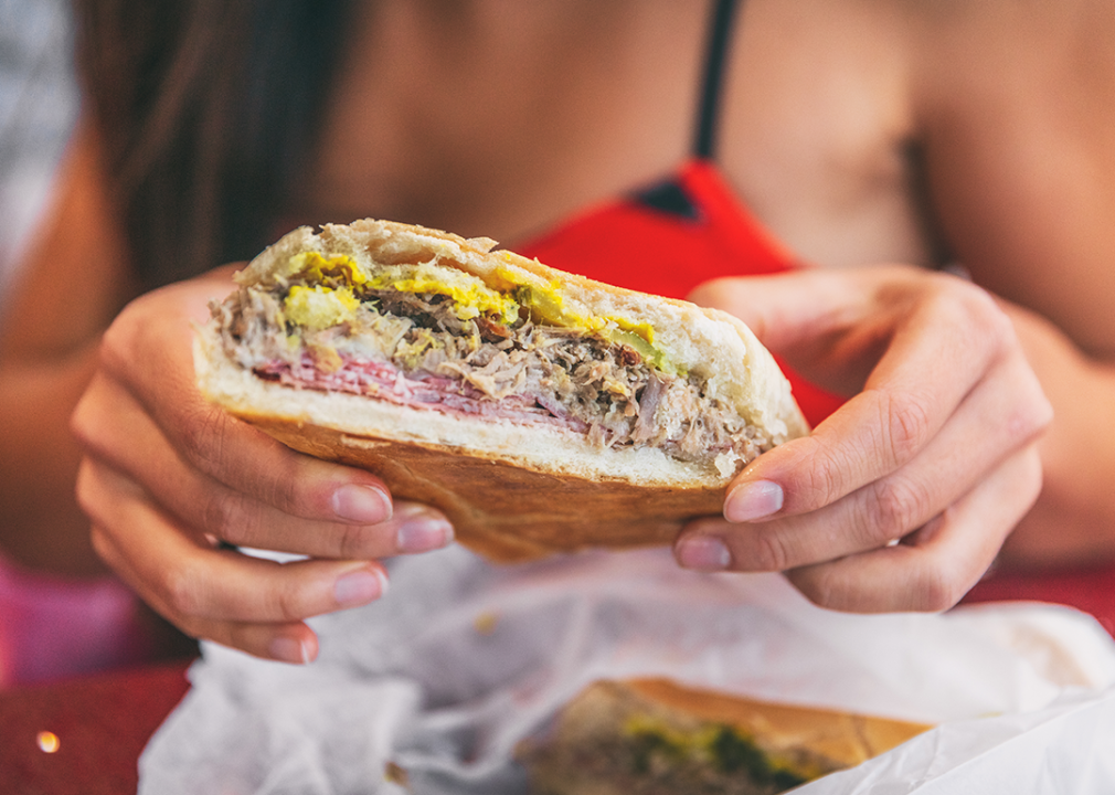 Close up of a person holding a Cubano.