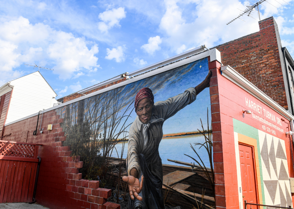 A photo taken at an upward angle of a mural of Harriet Tubman painted on the side of the Harriet Tubman Org.