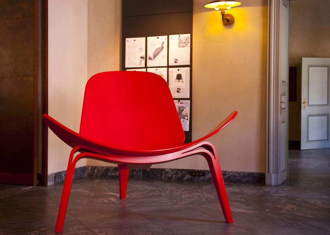 Red three legged Wegner shell chair in museum.