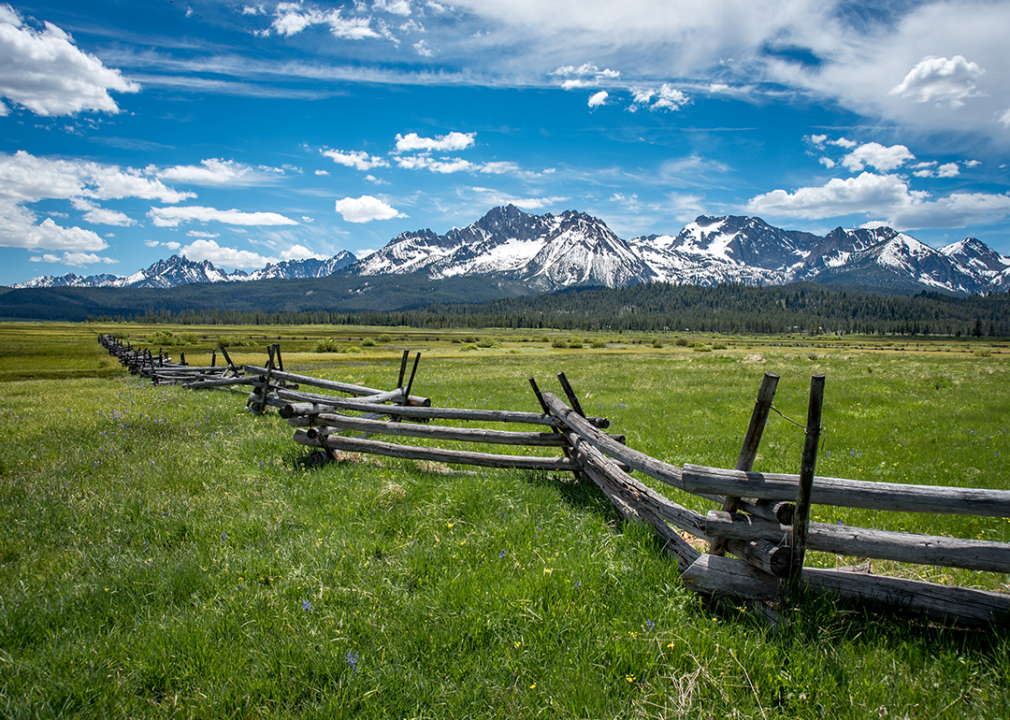 Wooden fence across pasture with Sawtooth Mountain Range.