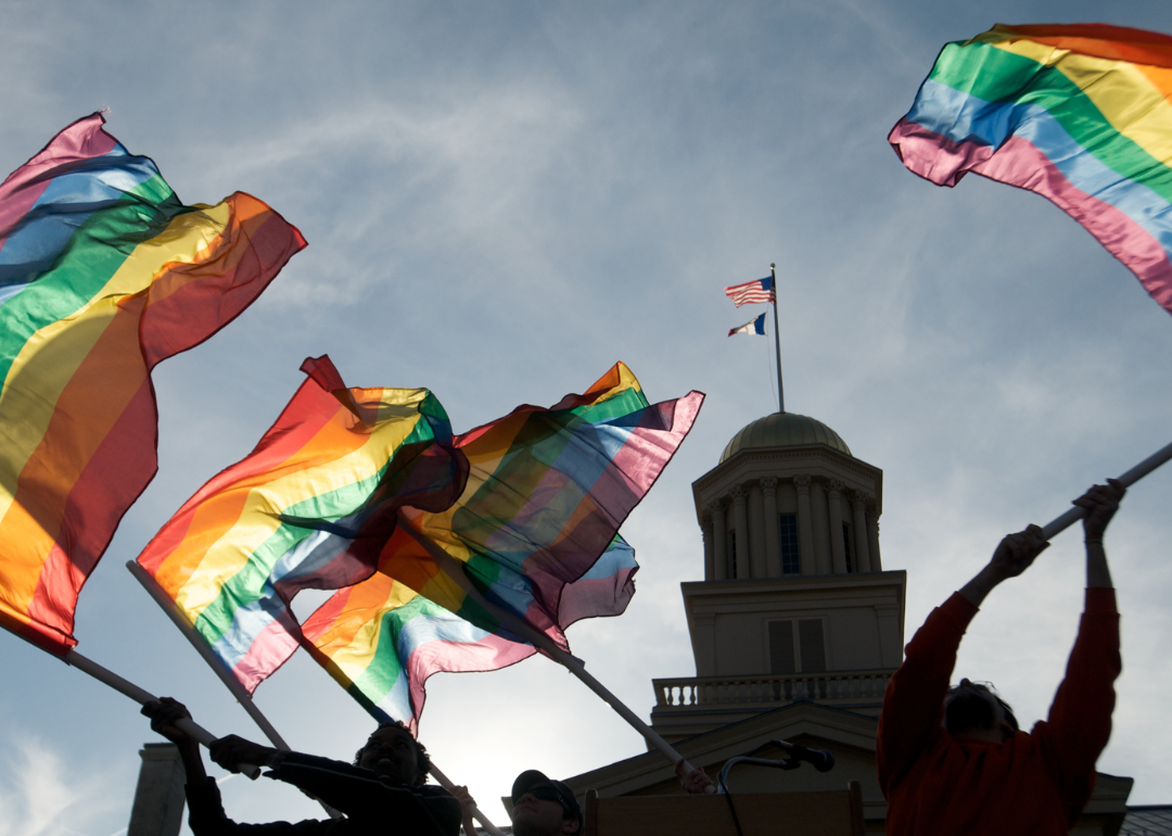 People waving pride flags outside of Iowa Supreme Court