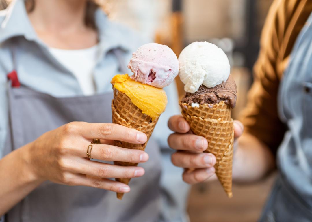 Two people cheers with ice cream cones.