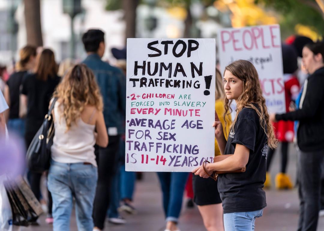 Young adult holding Stop Human Trafficking sign at awareness demonstration.
